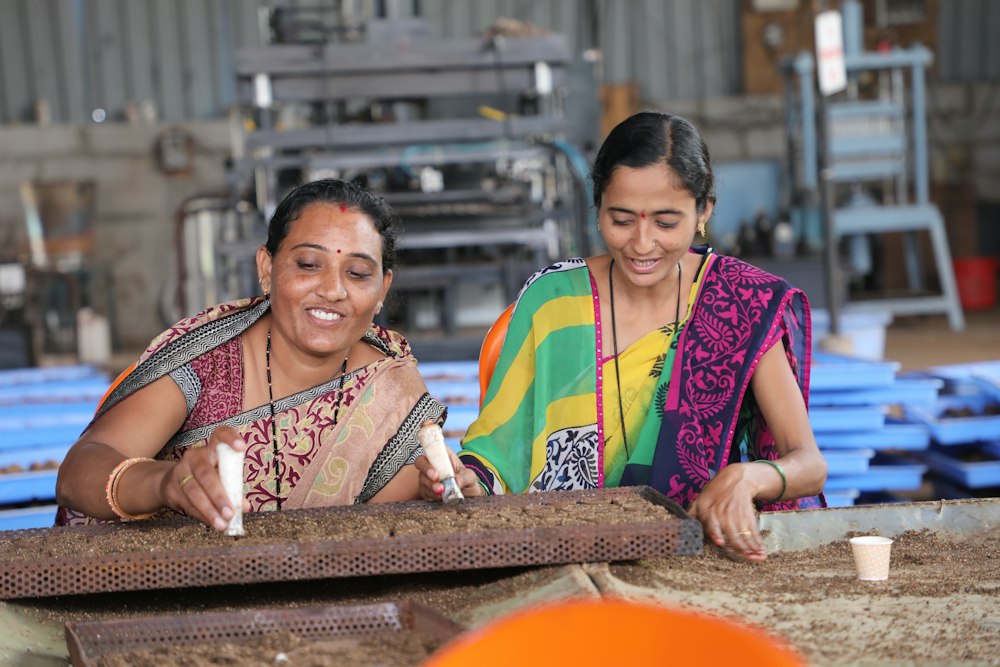 Two women working with seeds and soil